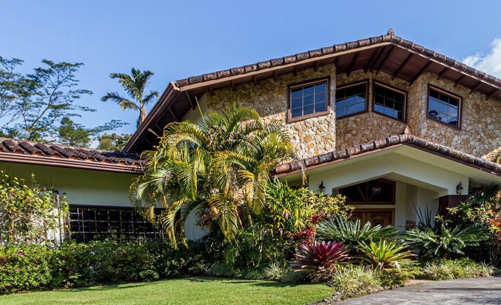 Exterior de una casa café con palmeras en Puebla